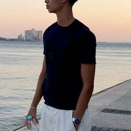 Person standing by a waterfront at sunset